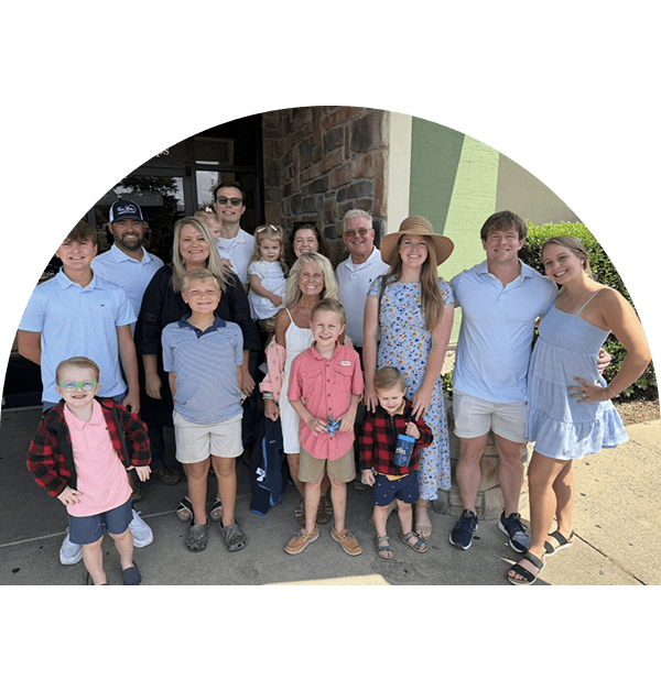 Family and friends gathered outdoors on a sunny day.